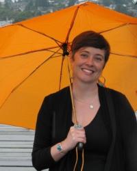 Heather D. Evans, white woman smiling holding brightly colored umbrella